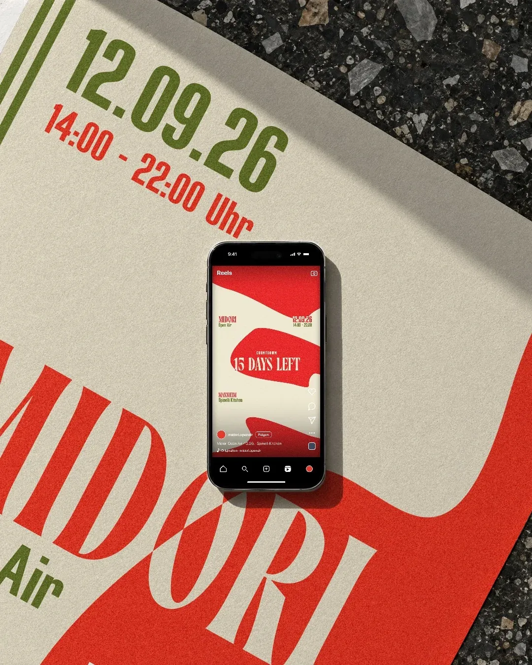 Ein Handy liegt auf einem Plakat von Midori Open Air mit dem Datum 12.09.26, darauf der Countdown