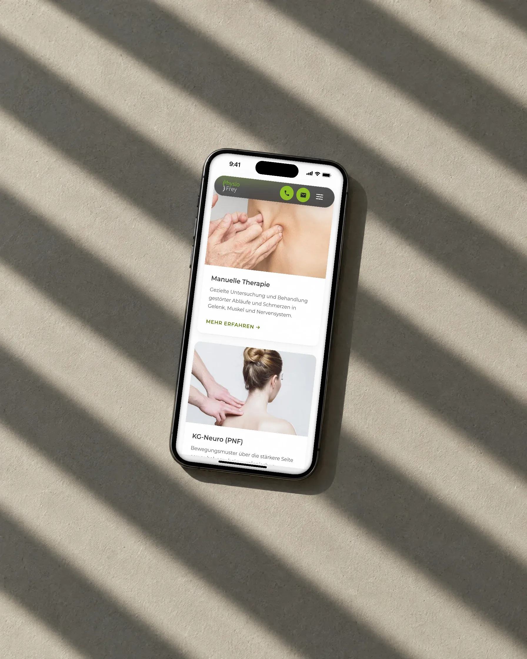 Ein Handy liegt im harten Licht einer Jalousie auf hellem Putz, darauf die Behandlung Manuelle Therapie von Physio Frey
