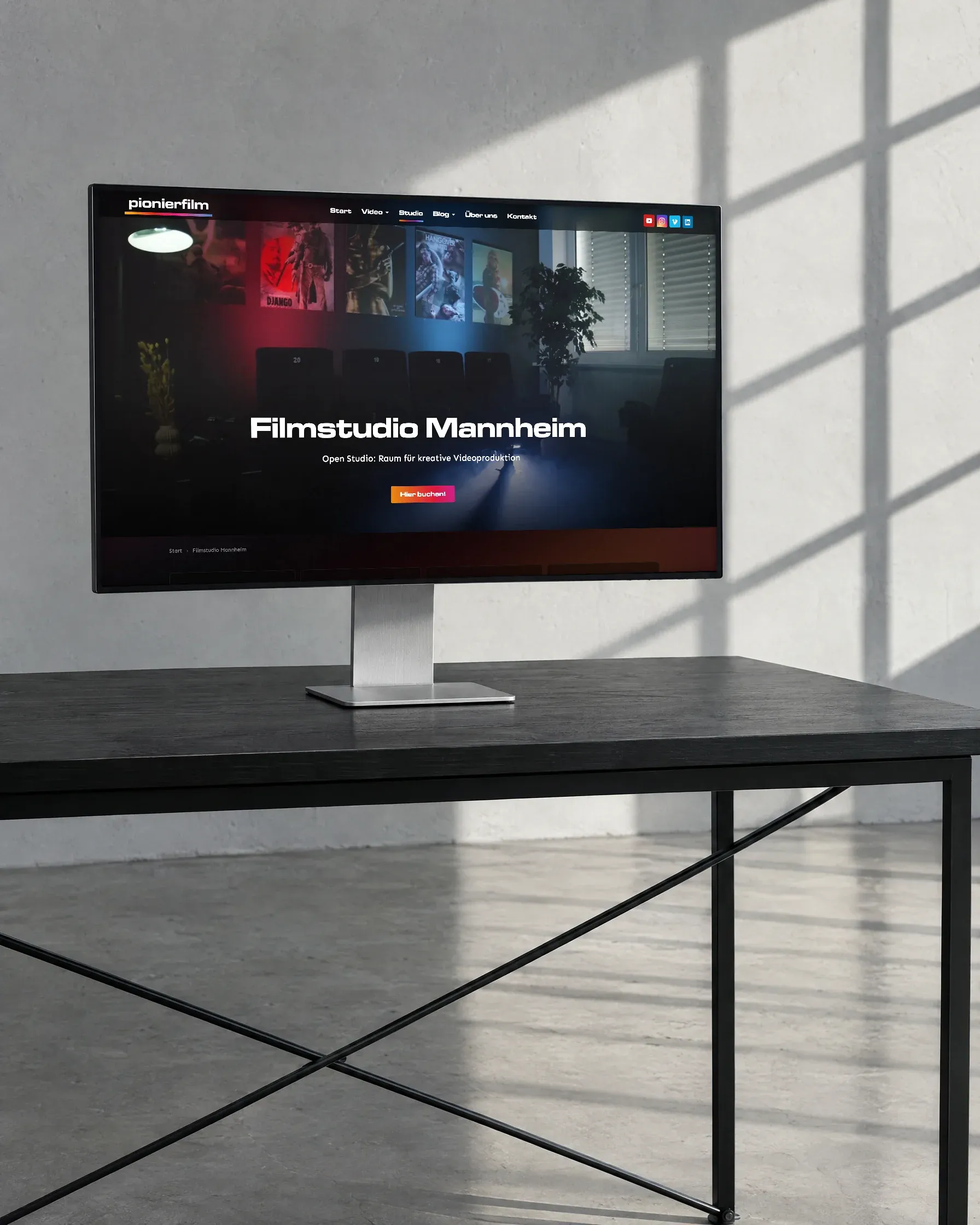 Ein Bildschirm steht allein auf einem schwarzen Tisch im Filmstudio und zeigt die Studioseite von Pionierfilm
