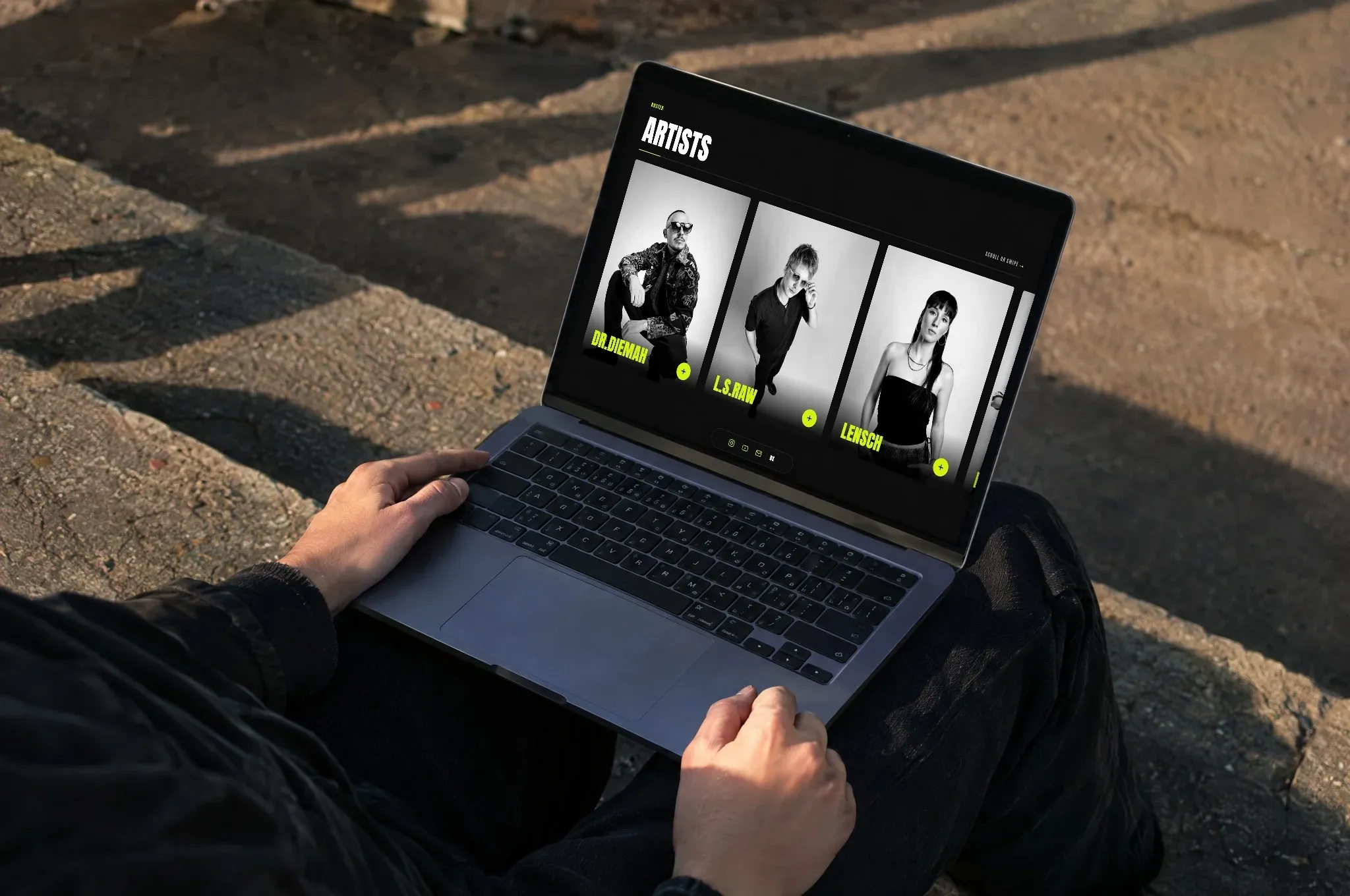 Ein Laptop auf den Knien, darauf das Roster von Joscot, in der Abendsonne auf Betonstufen